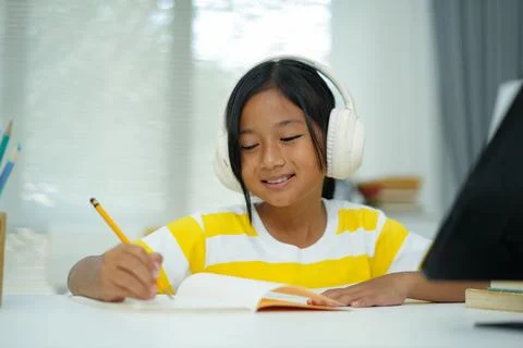 Happy young student using tablet with headphones for engaging online learni.. Foto stock