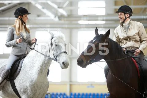 Happy young woman and man sitting on the horses Stock Photos