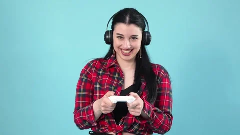 Happy Young Woman Gaming with Controller and Headphones Stock Footage 345538656