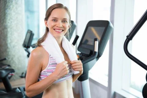 Happy young woman relaxing after cycling in gym Stock Photos