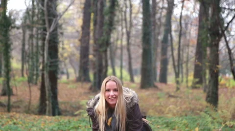 Happy young woman smiling and throwing leaves in the air Stock Footage 59553859