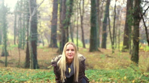 Happy young woman smiling and throwing leaves in the air Stock Footage 59553870