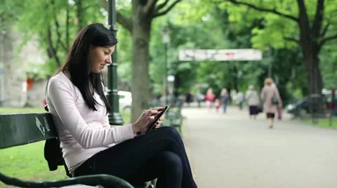 Happy young woman with tablet computer in the city park HD Stock Footage 11136872