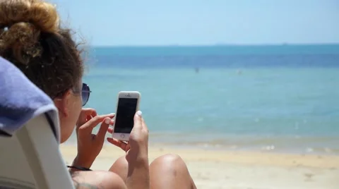 Happy Young Woman Using her Smartphone on the Beach Video stock 50868692