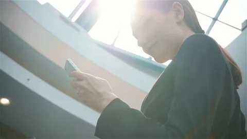 Happy young woman using smart phone in shopping mall. Businesswoman freelancer Stock Footage