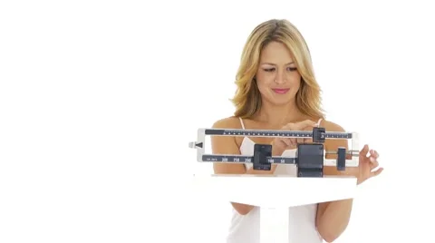 Happy young woman weighing herself on scale Stock Footage