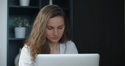 Happy young woman working in office, typing on laptop, smiling. Favorite work. Stock Footage