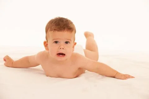 Hapy baby boy in playing on bed isolated over white Stock Photos