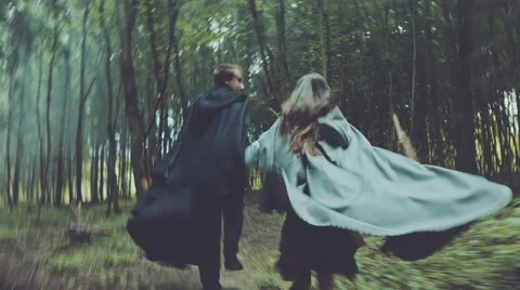 Harassment two unknowns in raincoats, running misty forest Stock Footage 54712299