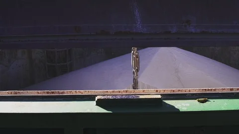 Harbor crane jaw unloading cargo from bulk carrier Stock Footage 114509461