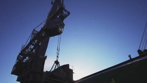 Harbor crane unloading cargo with blue sky in background Stock Footage 114509346