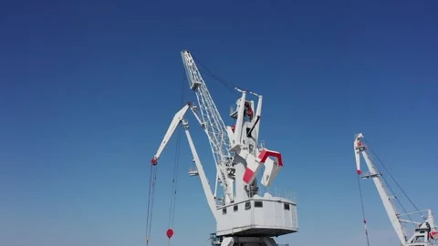 Harbor cranes lifting cargo under clear sky Video stock 347518470