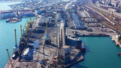 Harbor facilities operate with cranes and cargo at a busy port during daylight Video stock 336533291