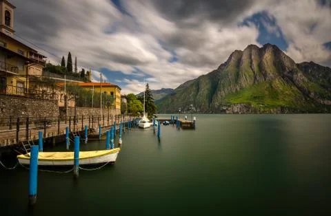 Harbor of Riva di Solto on Iseo Lake with mountains on background, Italy Stock Photos
