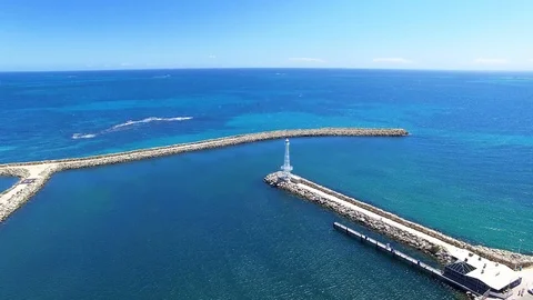 Harbor rocks, lighthouse and ocean aerial footage Stock Footage 98736476