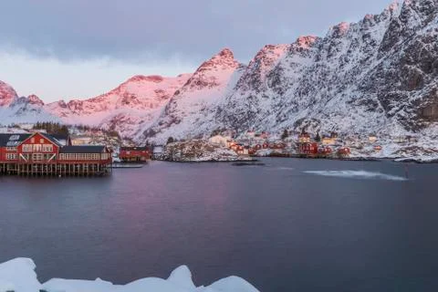 Harbor, rorbuer and snowy mountains at sunrise in A, Lofoten Stock Photos