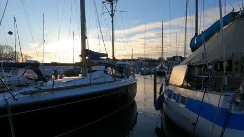 Harbor with sailing yachts in winter time. Sunset and solar panels. 動画素材 148239441