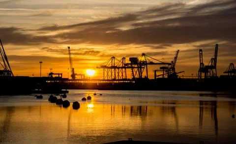 Harbor sunrises load cargo cranes at port ready to load containers on ships Stock Photos