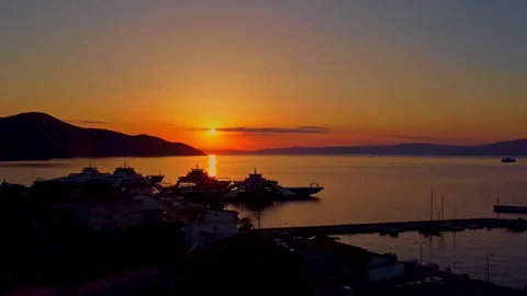 Harbor in Thasos Greece at sunset with small boat moving on calm sea aerial view 스톡 동영상 332557349
