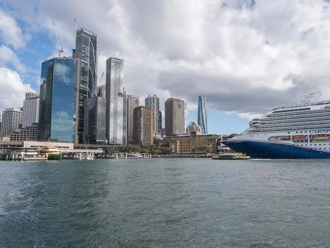 Harbor view features cruise ship and city skyline with tall towers Stock Photos