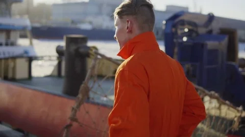 Harbor Worker in orange uniform is Walking on Cargo Harbor Site. Slowmotion Stock Footage 73275395