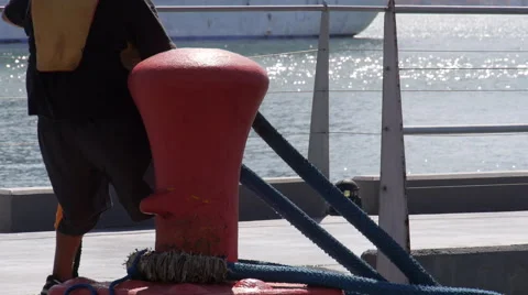 Harbor worker  placing mooring rope on mooring pole. close-up. Stock Footage 59507169
