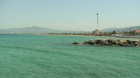 Harbour wall with beach in background 스톡 동영상 77737