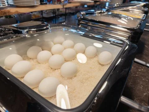 Hard boiled eggs arranged inside a stainless steel hotel buffet warmer for Stock Photos