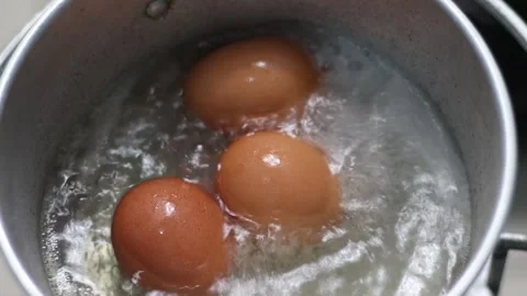Hard-boiled eggs in hot boiling water are cooked in a pan. 動画素材 174037668