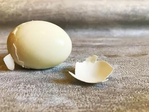 Hard boiled eggs with shell peeled on wooden table. Stock Photos