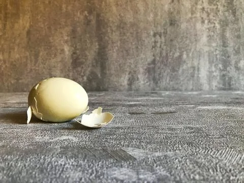 Hard boiled eggs with shell peeled on wooden table. Stock Photos