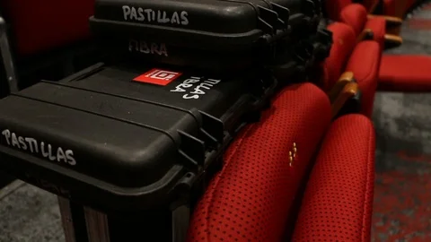 Hard carry case, event mics and radios, on theatre chairs at live event Stock Footage 98684714