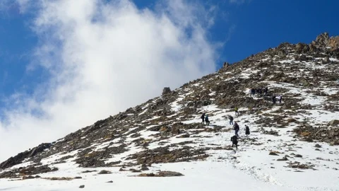 Hard difficult descent from a mountain. Group of climbers go down from snow hill Vidéo 115644209