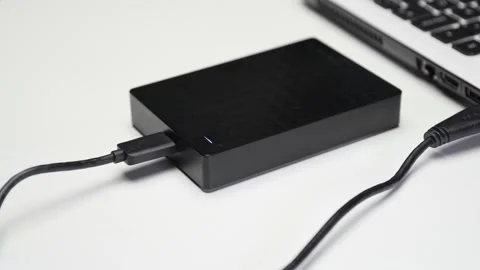 Hard disk connected to computer with light flashing, white background Stock Footage 143866054