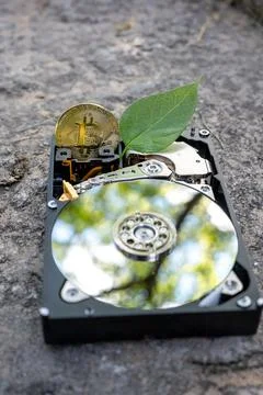 Hard disk drive with a bitcoin and a chia leaf on a concrete surface Stock Photos
