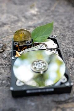 Hard disk drive with a bitcoin and a chia leaf on a concrete surface Stock Photos