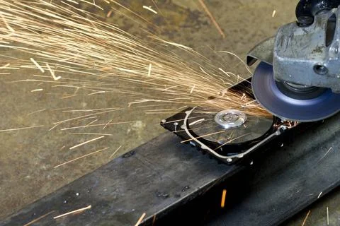 Hard disk grinding hard disk drive with rotating grinder and sparks in fro... Stock Photos