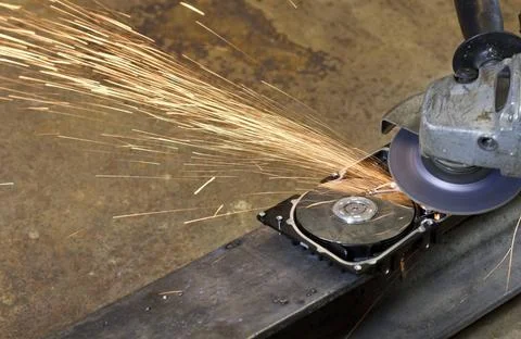 Hard disk grinding hard disk drive with rotating grinder and sparks in fro... Stock Photos