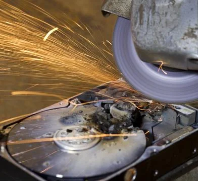 Hard disk grinding hard disk drive with rotating grinder and sparks in fro... Stock Photos