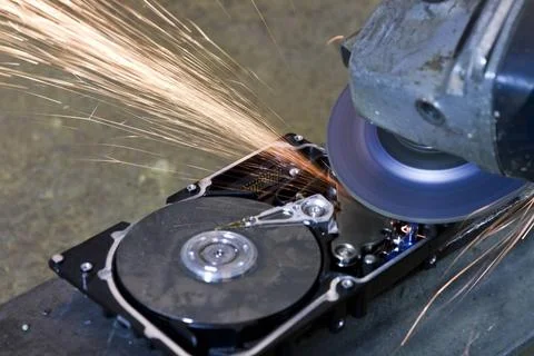 Hard disk grinding hard disk drive with rotating grinder and sparks in fro... Stock Photos