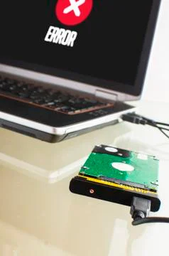 Hard disk laying on a table connected to the laptop for data rescue Stock Photos