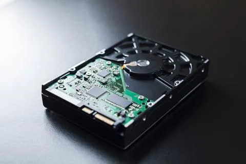 Hard disk on top of a table with its components and connections visible. Tech Stock Photos