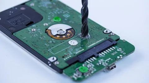 The hard drive from the computer is drilled with a large drill, macro photo Stockfoto's