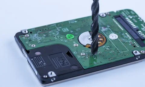 The hard drive from the computer is drilled with a large drill, macro photo 写真素材