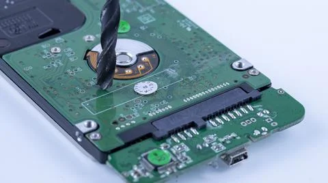 The hard drive from the computer is drilled with a large drill, macro photo 스톡 사진