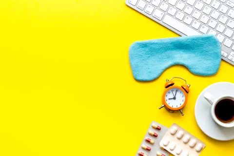 Hard exhausing work. Sleep mask on yellow office desk top-down copy space Stock Photos