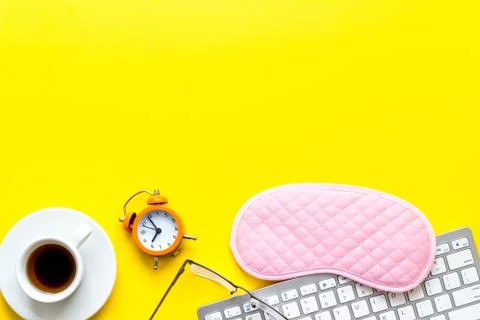 Hard exhausing work. Sleep mask on yellow office desk top-down copy space Foto stock