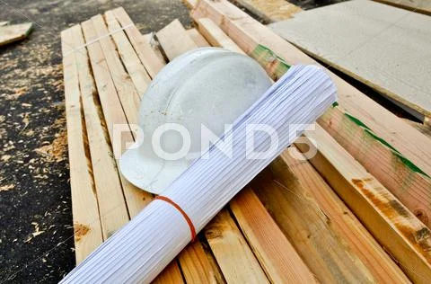 Hard hat and plans Stock Photos