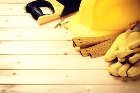Hard hat and various tools on wooden background Stock Photos