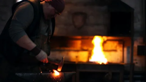 Hard men work. Blacksmith knocks with a hammer Stock Footage 100234279